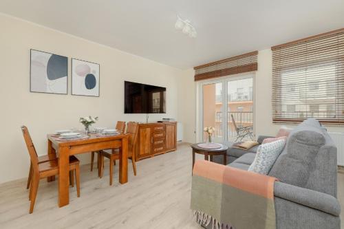 a living room with a couch and a table at Wilczak Spacious Apartment with FREE GARAGE Poznań by Noclegi Renters in Poznań