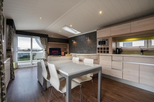 a kitchen with a white table and white chairs at ELVIS, King Of The Caravans, Luxury 6 berth in Port Seton