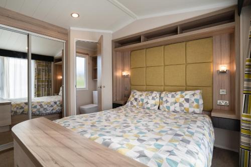 a bedroom with a large bed in a room at ELVIS, King Of The Caravans, Luxury 6 berth in Port Seton