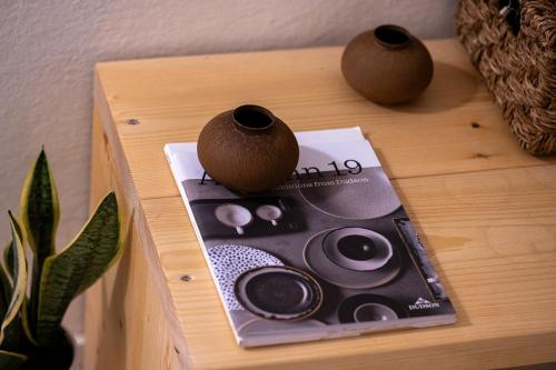 a table with a book and two vases on it at Capella Town, Skiathos in Skiathos Town