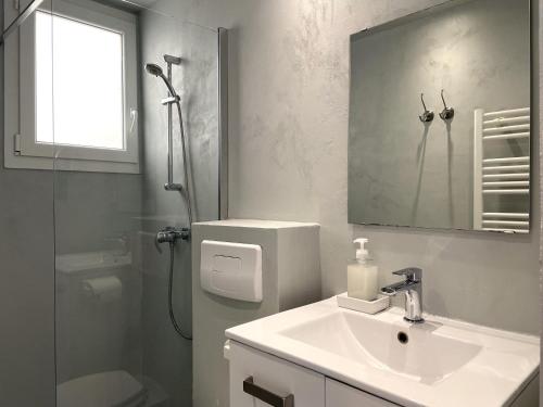 y baño con lavabo, ducha y espejo. en TUSQUETS - Apartamento con vistas al mar, en Cadaqués