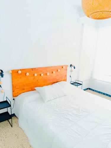 a white bed with a wooden headboard in a bedroom at EL CARPIO CENTRO - Córdoba - WiFi in El Carpio