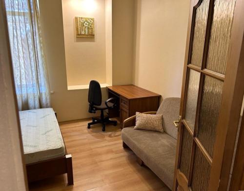 ein Wohnzimmer mit einem Sofa und einem Schreibtisch in der Unterkunft Апартаменти 3-кімнатні, м. Майдан Незалежності in Kiew