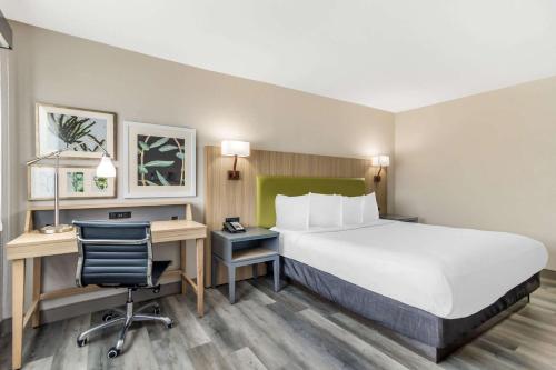 Habitación de hotel con cama grande y escritorio. en Country Inn & Suites by Radisson, Atlanta Airport South, GA en Atlanta