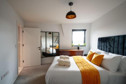a bedroom with a large bed with towels on it at Beautiful & Contemporary Watford Retreat in Watford