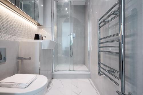a bathroom with a shower and a toilet and a sink at Beautiful & Contemporary Watford Retreat in Watford