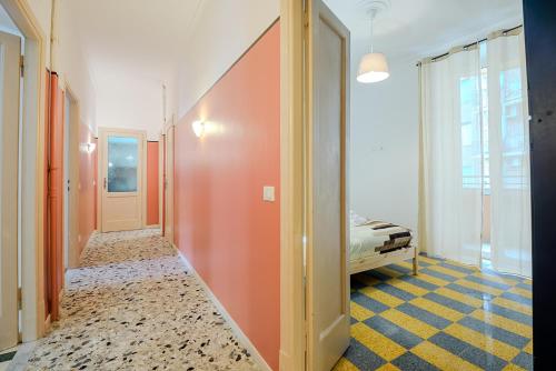 un couloir aux murs orange et un lit dans une chambre dans l'établissement Galazia Apartment San Giovanni, à Rome