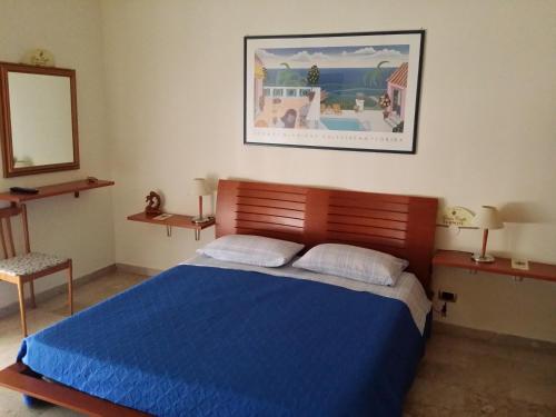 sypialnia z niebieskim łóżkiem i lustrem w obiekcie Aparthotel TURNONE w mieście Tarent