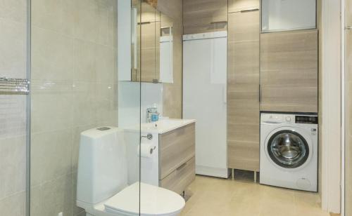 een badkamer met een toilet en een wasmachine bij Villa Lusma in Inari