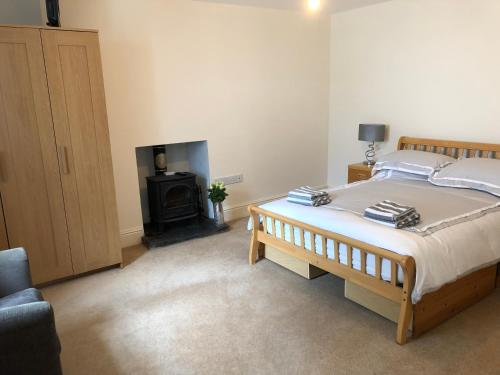 a bedroom with a large bed and a fireplace at White Lion Aberporth in Aberporth
