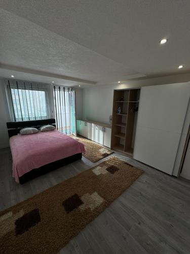 - une chambre avec un lit rose et un tapis dans l'établissement Apartman Kumalic, à Sanski most