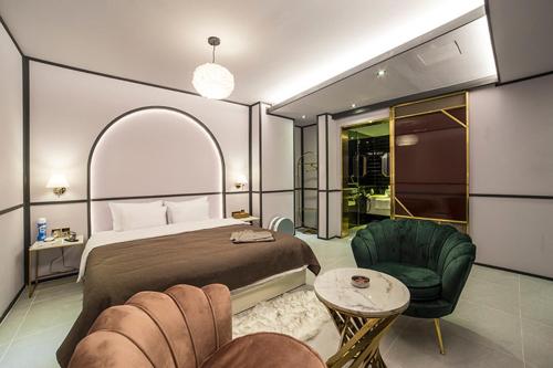 una camera con letto, divano e sedia di Denbasta Hotel a Busan