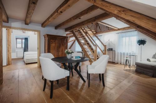 a living room with a table and white chairs at Romantik Spa Hotel Elixhauser Wirt in Elixhausen