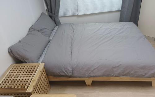 a bed in a room next to a window at Haeundae Mipo House1 in Busan