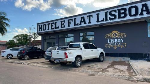 un camión blanco estacionado frente a un edificio en Hotel E Flats LISBOA, en Presidente Médici