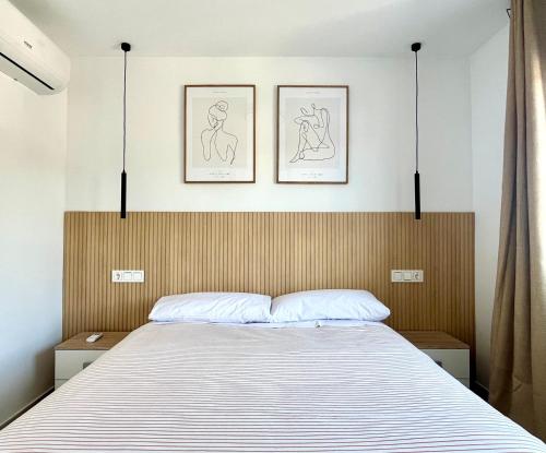 a bedroom with a bed with two pictures on the wall at Perseo by Albir Proper Properties in Albir