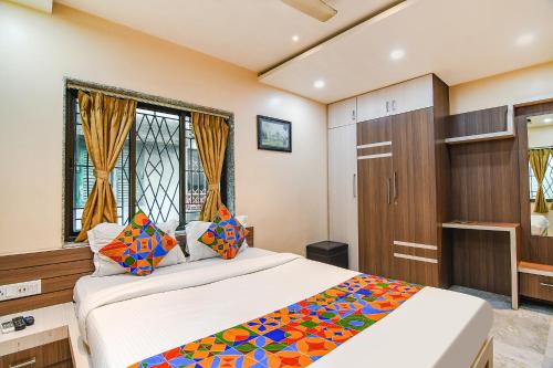 um quarto com uma cama grande e um armário de madeira em FabExpress Scholer Motel em Calcutá