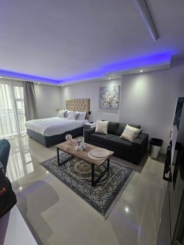 a living room with a bed and a couch at Glorystar The Millennial Umhlanga in Durban