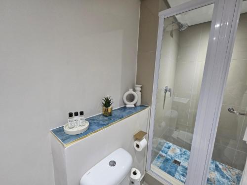 a bathroom with a white toilet and a shower at Glorystar The Millennial Umhlanga in Durban