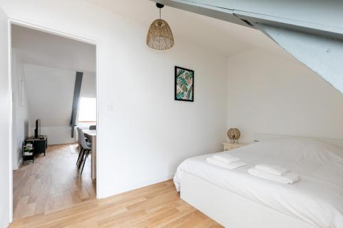 瓦訥的住宿－bel appartement refait a neuf，白色卧室配有床和书桌