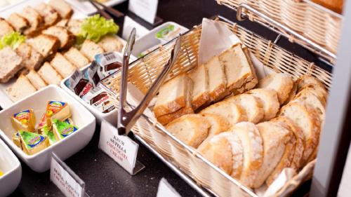 a bunch of bread and pastries in baskets on a table at Vestil Hotel in Piotrków Trybunalski