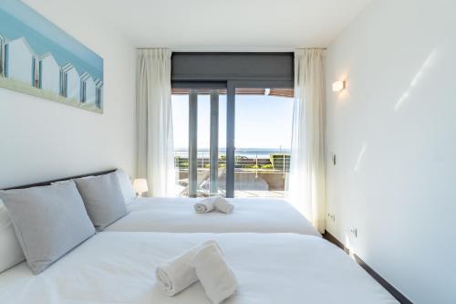 una camera da letto con un letto bianco con una grande finestra di NC APARTMENTS 201 Moli Blau - 4 pax a Roses