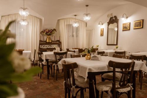 een restaurant met tafels en stoelen met witte tafelkleden bij Allegro Hotel in Ljubljana