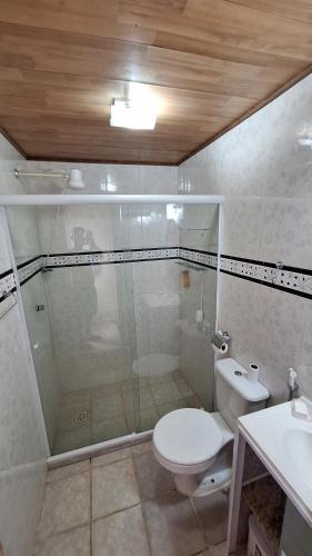 um banheiro com chuveiro, vaso sanitário e pia em casa suite cabo frio em Cabo Frio