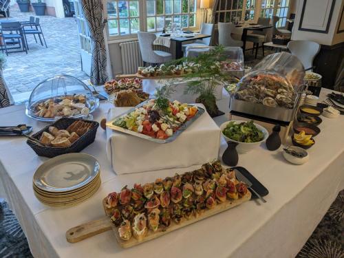 a table with many different types of food on it at Hotel Le Lion D'Or et Restaurant La Table Du Lion in Bayeux