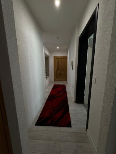 a hallway with a red carpet and a door at Apartman Kumalic in Sanski most