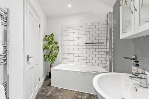 Baño blanco con bañera y lavamanos en Deluxe Central Bath House - Sleeps 7, en Bath