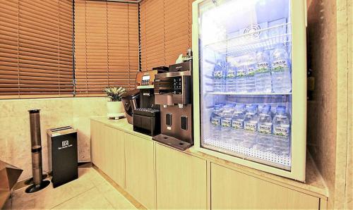 un negozio con un frigorifero pieno di acqua in bottiglia di Denbasta Hotel a Busan