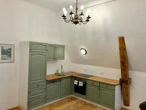 a kitchen with green cabinets and a chandelier at Herrnhof in Reichenau