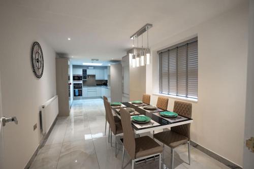 a kitchen and dining room with a table and chairs at Luxury 6 Bed near city centre with Cinema Room & games room plus 5 bathrooms in Manchester