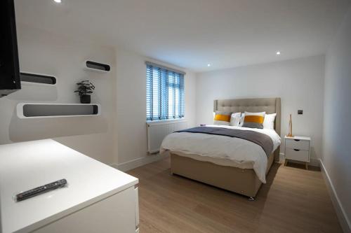 a white bedroom with a bed and a window at Luxury 6 Bed near city centre with Cinema Room & games room plus 5 bathrooms in Manchester