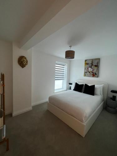 a white bedroom with a white bed and a window at Modern and spacious two bedroom apartment near city centre in Bristol