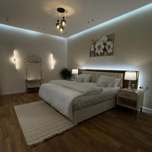 Un dormitorio con una gran cama blanca y una mesa en شاليهات سيليا الفندقية, en Al Mubarraz