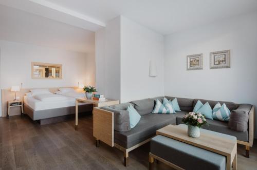 ein Wohnzimmer mit einem Sofa und einem Bett in der Unterkunft Romantik Spa Hotel Elixhauser Wirt in Elixhausen