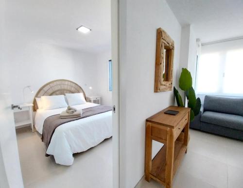 a bedroom with a bed and a blue couch at Royal Blue Corralejo by Sea You There Fuerteventura in Corralejo