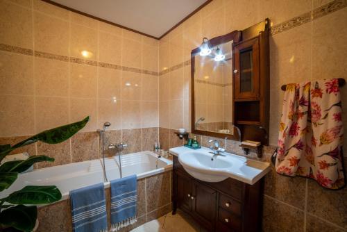 een badkamer met een bad, een wastafel en een bad bij Apartmán Moonrise U Mluvících kamenů in Staré Křečany