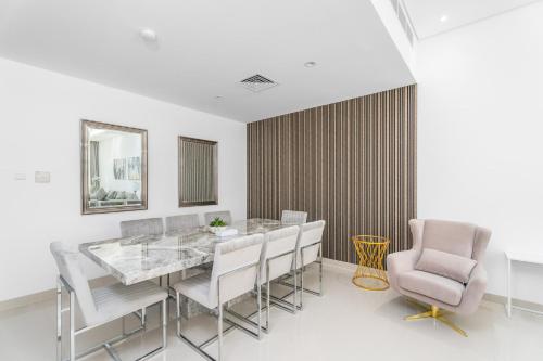 a dining room with a table and chairs at Nasma Luxury Stays - Luxurious Villa with Private Pool & Close to Beach in Fujairah