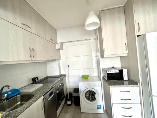 a kitchen with a washing machine and a microwave at VibesCoruña - Bergondo 10 in A Coruña