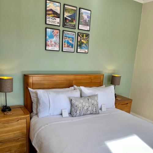 a bedroom with a bed with four pictures on the wall at The Devonian in Ilfracombe