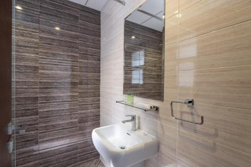 a bathroom with a sink and a mirror at Nasma Luxury Stays - Luxurious Villa with Private Pool & Beach Access in Fujairah