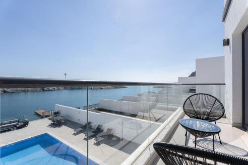 a balcony with two chairs and a swimming pool at Nasma Luxury Stays - Luxurious Villa with Private Pool & Close to Beach in Fujairah