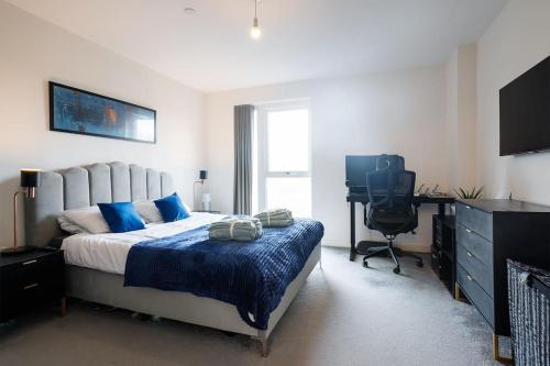 Beautiful & Contemporary Queensbury Retreat في Wealdstone: غرفة نوم بسرير ومكتب وجهاز كمبيوتر