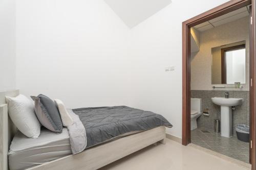 a bedroom with a bed and a bathroom with a sink at Nasma Luxury Stays - Luxurious Villa with Private Pool & Close to Beach in Fujairah