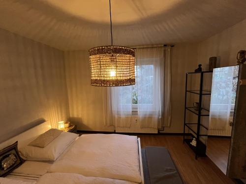 um quarto com uma cama, um lustre e uma janela em sennefeeling em Hövelhof