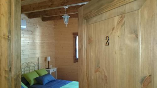 CobisaにあるCasa Rural La Dehesa De Toledoの木製の壁の客室で、ベッドが備わります。