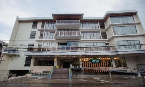 a large white building with stairs in front of it at Maxi Hotel and Event Center in Tagbilaran City